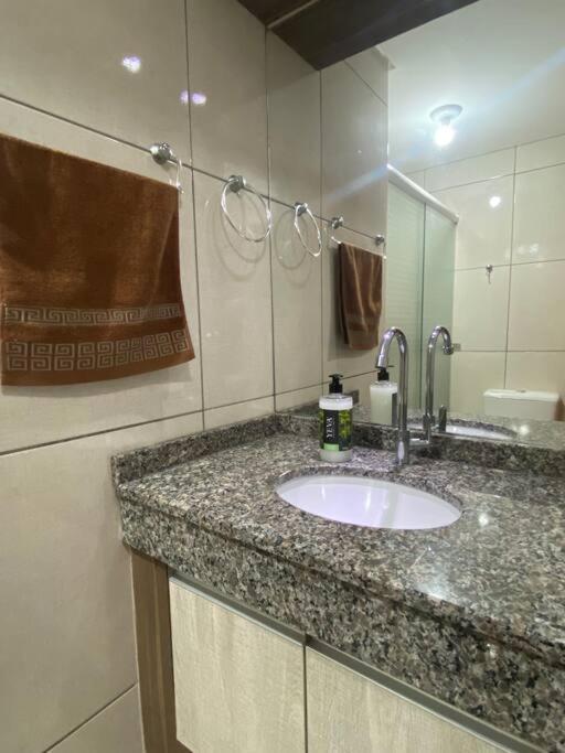 une salle de bain avec un lavabo et un miroir dans l'établissement Apartamento Inteiro - 2 Quartos com AC - Wifi 300mb - Cozinha Completa - 1 Vaga de Garagem - TV Smart 50 - Sacada - Indicado para Grupos, Hospedes a Trabalho, Família e Pets, à Toledo