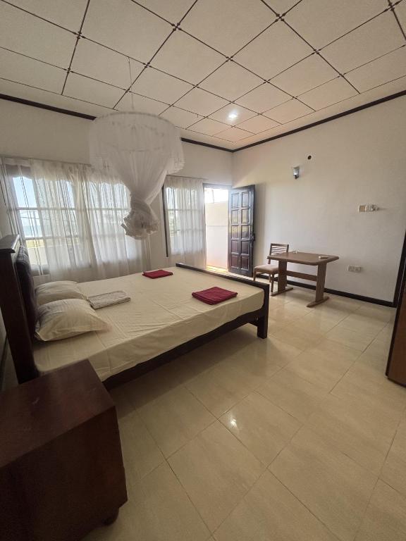 a bedroom with a large bed and a table at Nihal Bay View in Matara