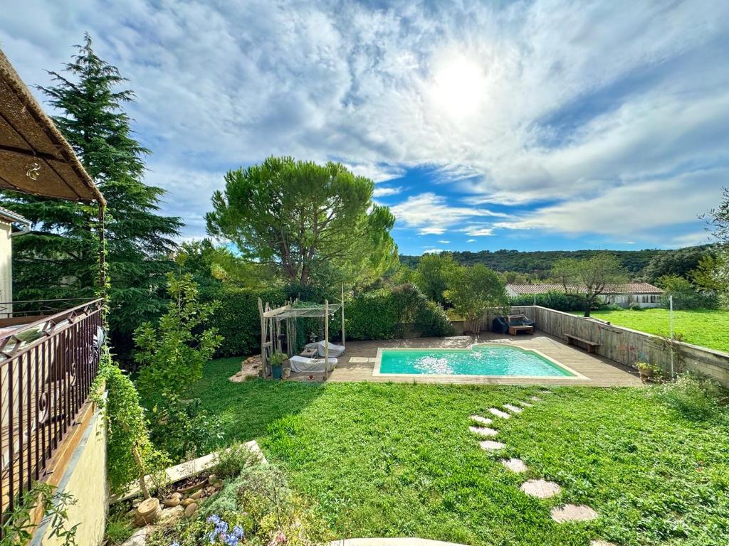 une cour avec une piscine et une clôture dans l'établissement La Villa Verte - Piscine privative, à Montpezat