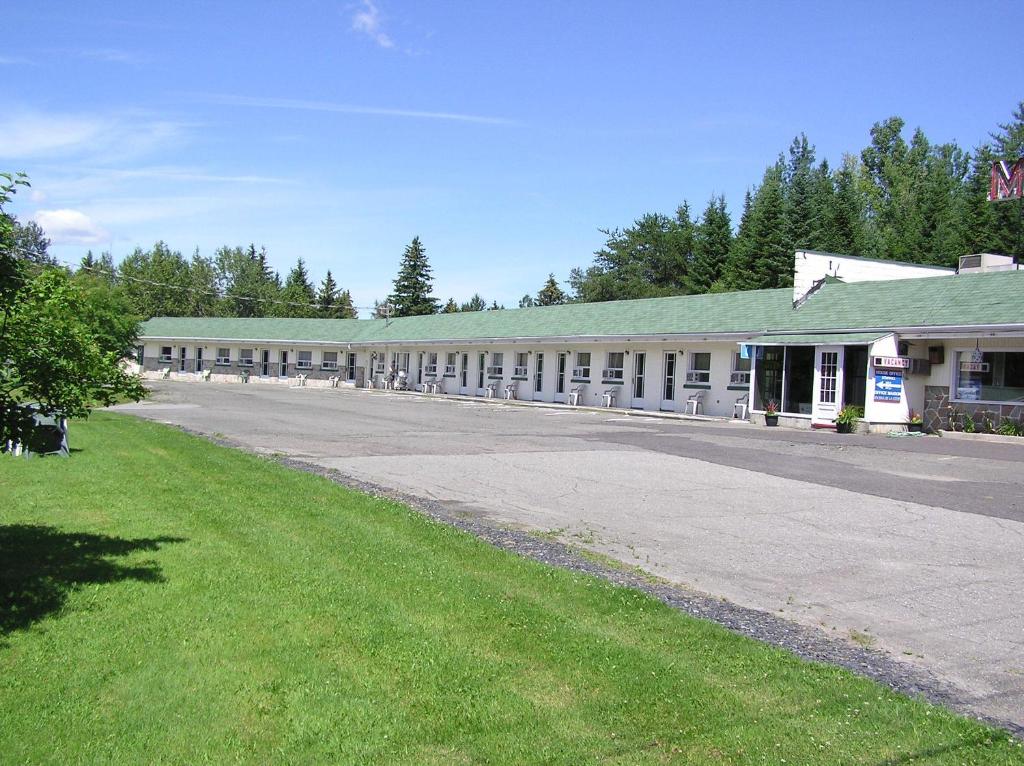 un aparcamiento vacío frente a un edificio en La Roma Motel en Edmundston