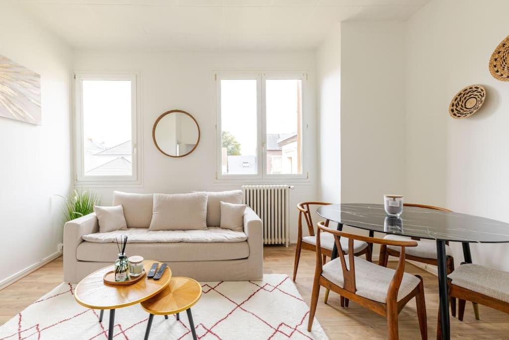 un salon avec un canapé et une table dans l'établissement Le Gambetta Rouen, à Saint-Étienne-du-Rouvray