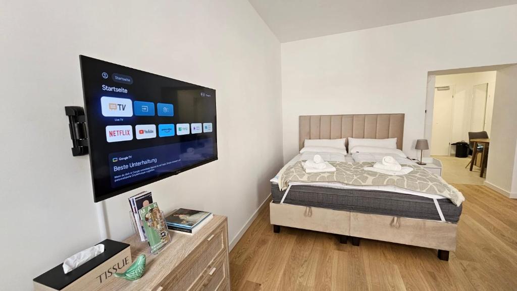 a bedroom with a bed and a flat screen tv at City Apartment nahe Schönbrunn 10 in Vienna
