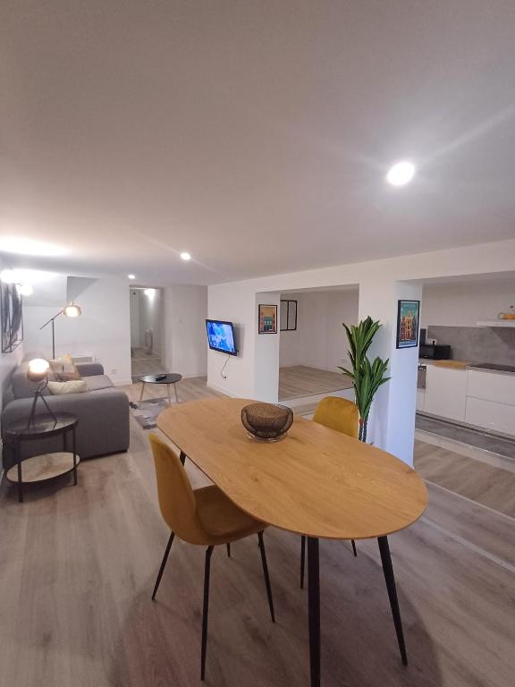 un salon avec une table et un canapé dans l'établissement le loft du canal, 2 lits, baignoire balnéo, wifi, à Agen