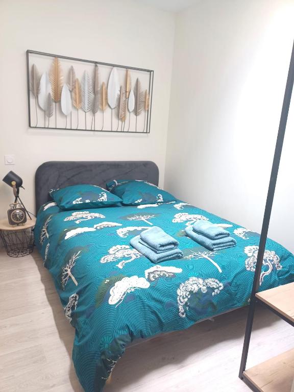 - un lit avec une couette bleue et des serviettes dans l'établissement Le studio du canal, 2 pers, wifi, à Agen