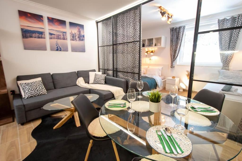 a living room with a couch and a glass table at Bella Apartment - Sunčana dolina in Kopaonik