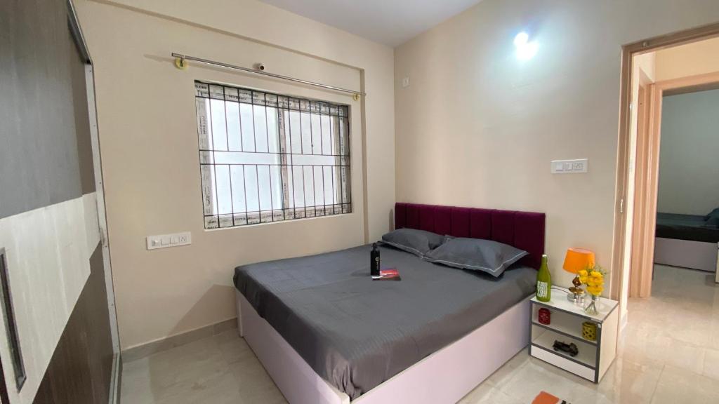 a bedroom with a bed and a window at C Suites - Fallon in Bengaluru