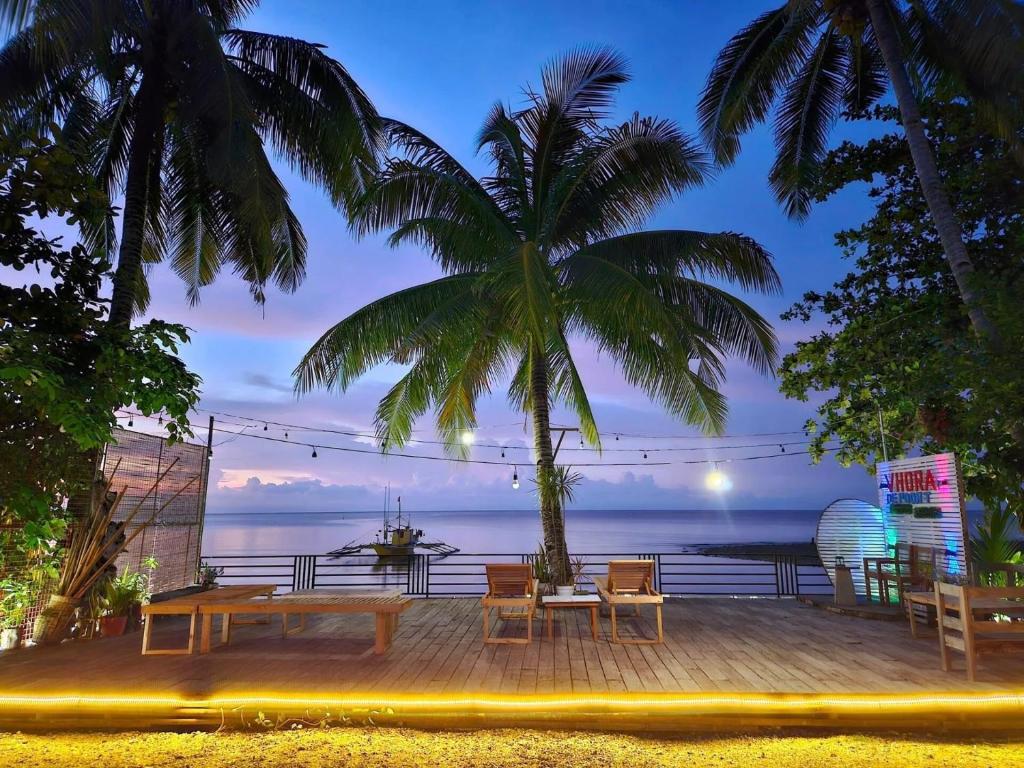 MagdiwangVhora Resort的一个带桌椅和棕榈树的庭院