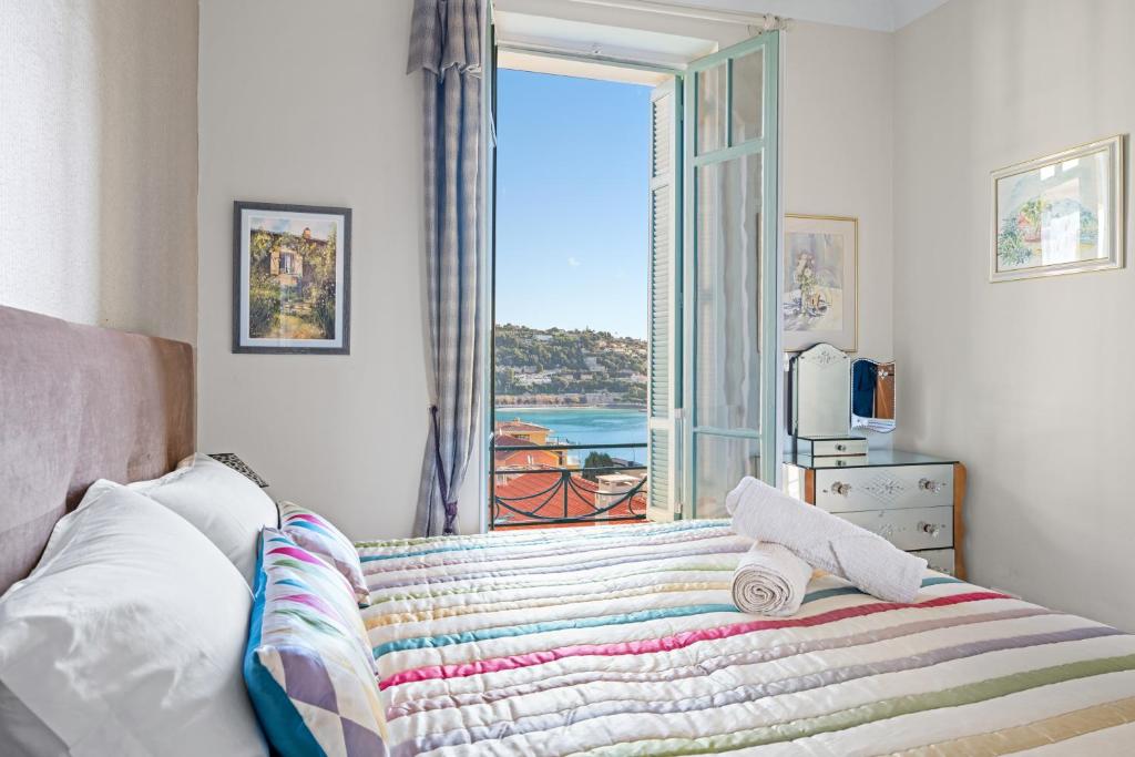 Un dormitorio con una cama con vista al mar. en Appartement d Exception, Spacieux et Lumineux, avec Balcon et Vue Mer, en Villefranche-sur-Mer