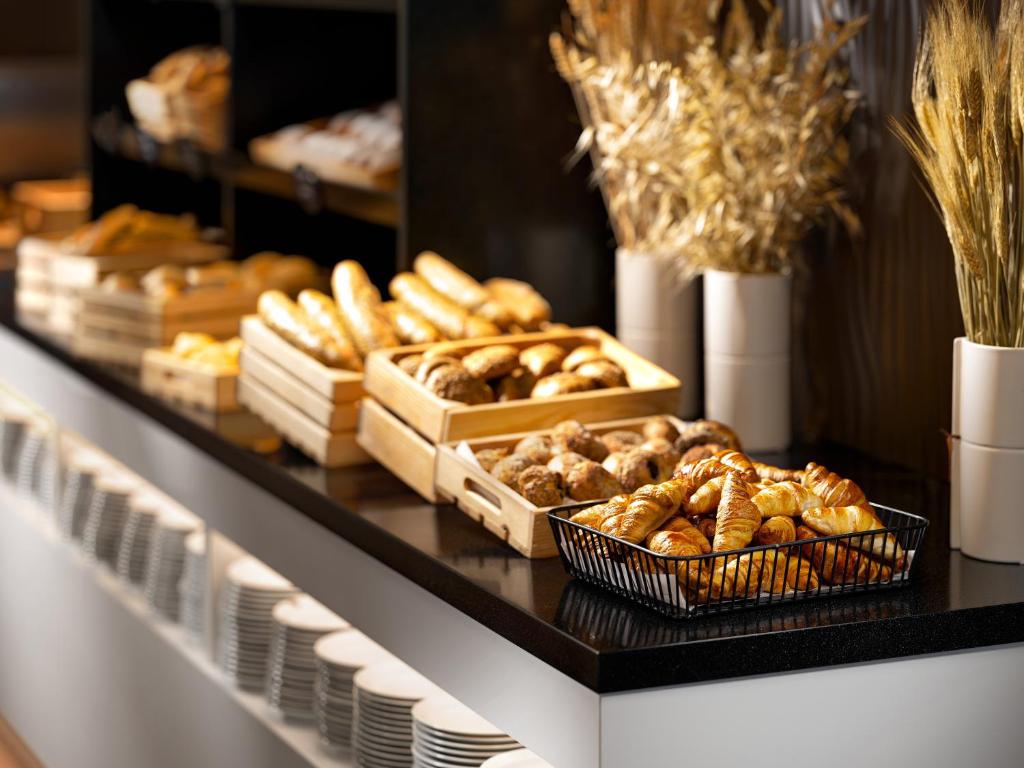 a bakery with breads and pastries on a counter at Clarion Congress Hotel České Budějovice in České Budějovice