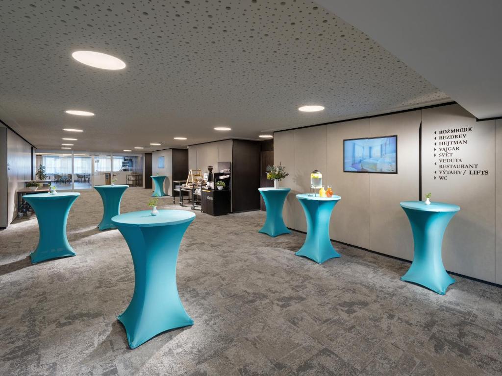 a waiting room with blue stools in a lobby at Clarion Congress Hotel České Budějovice in České Budějovice
