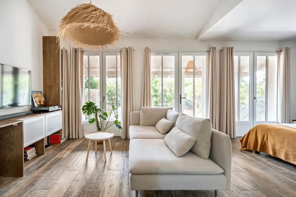 CassyにあるAppt Premium environnement boise Bassin d Arcachonのソファとテレビのあるリビングルーム