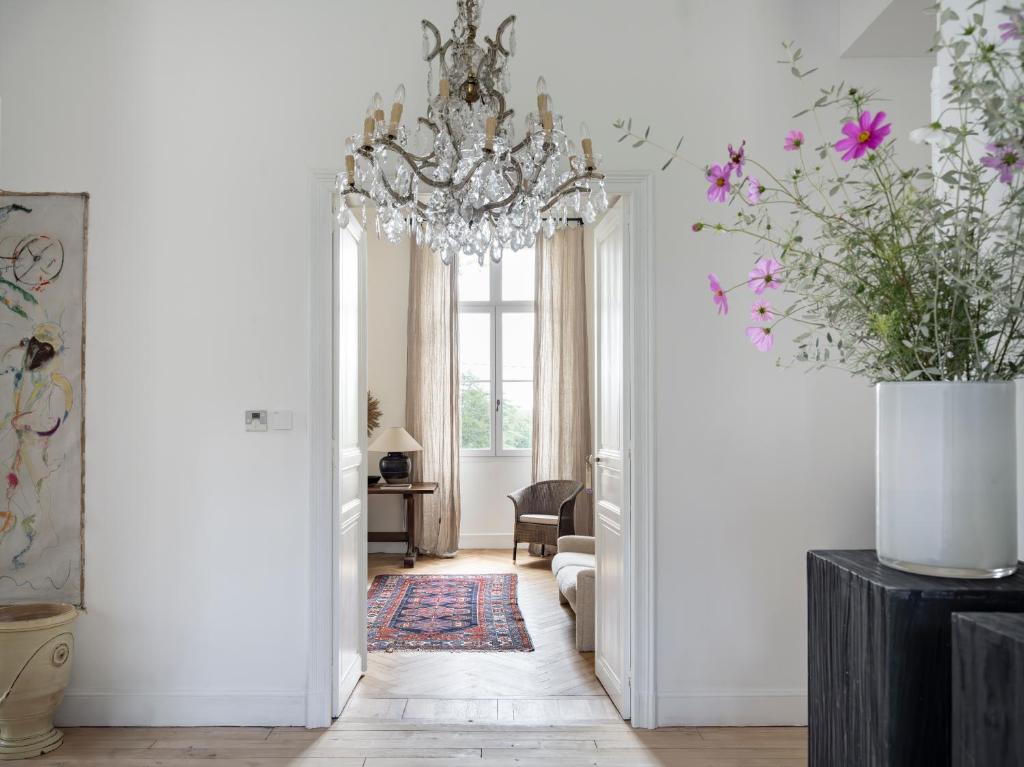 a hallway with a chandelier and a living room at La Grande Maurague, Boutique Guesthouse with Pool in South of France, Peaceful countryside Stay in the Gers in Condom