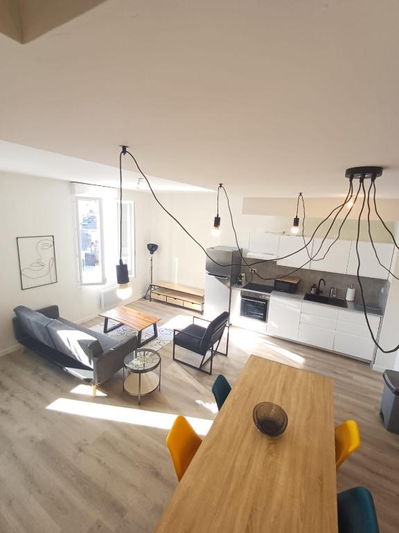 un salon avec une table et un canapé dans l'établissement Superbe T5 , 4chs, 8pers, parking privé, wifi, à Agen