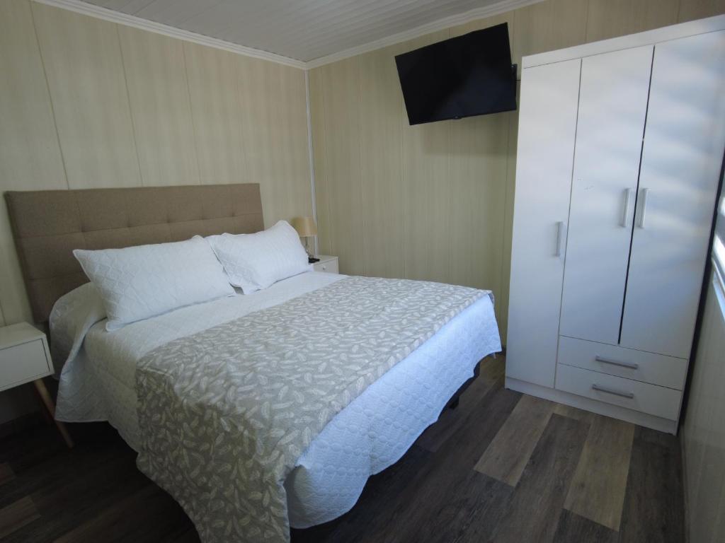 a bedroom with a bed and a white cabinet at Hotel Cecil in Vallenar