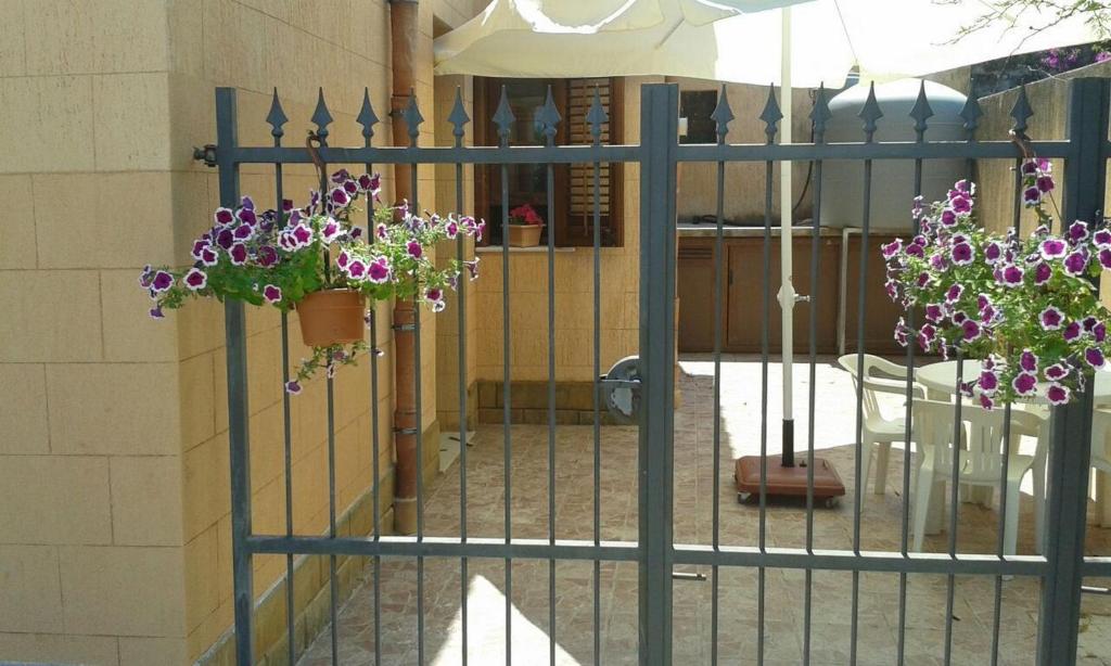 a gate with purple flowers hanging from it at Casa Eva in Castelluzzo