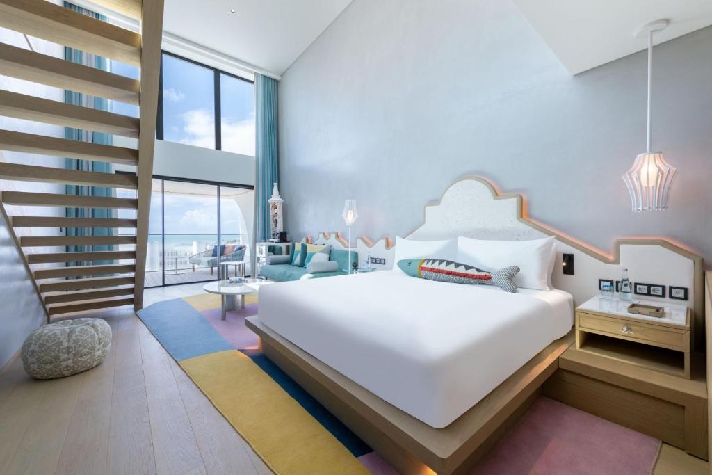 a bedroom with a white bed and a staircase at W Algarve in Albufeira