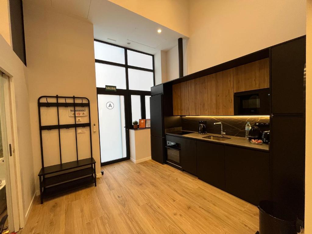 a kitchen with black cabinets and a wooden floor at LOFT Accommodative A in Valencia