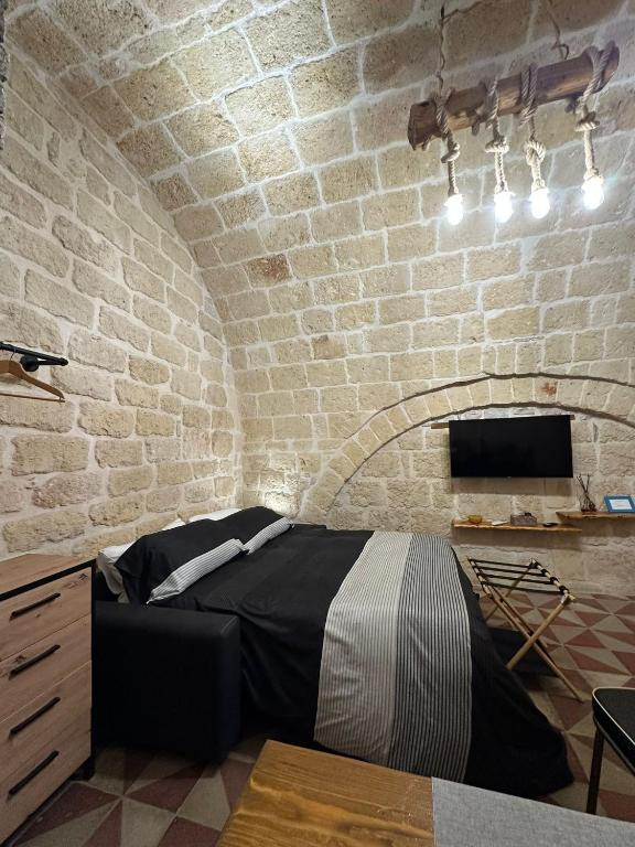 a bedroom with a bed in a brick wall at Room Pietra Bianca in Corato