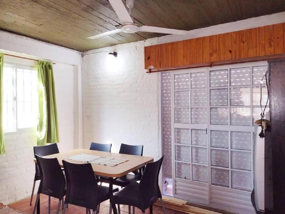 a dining room with a table and chairs and a window at Casita del Mar in Las Toninas