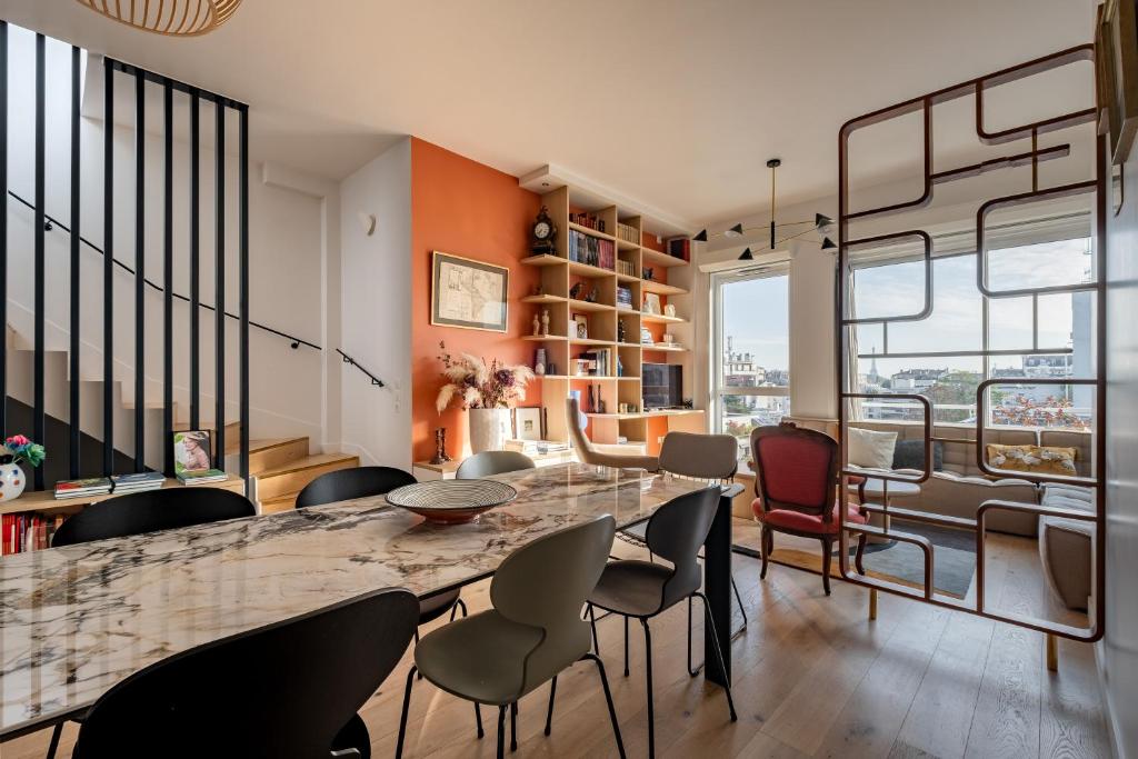 une salle à manger avec une grande table et des chaises en marbre dans l'établissement Veeve - Eyes Towards the Eiffel, à Boulogne-Billancourt
