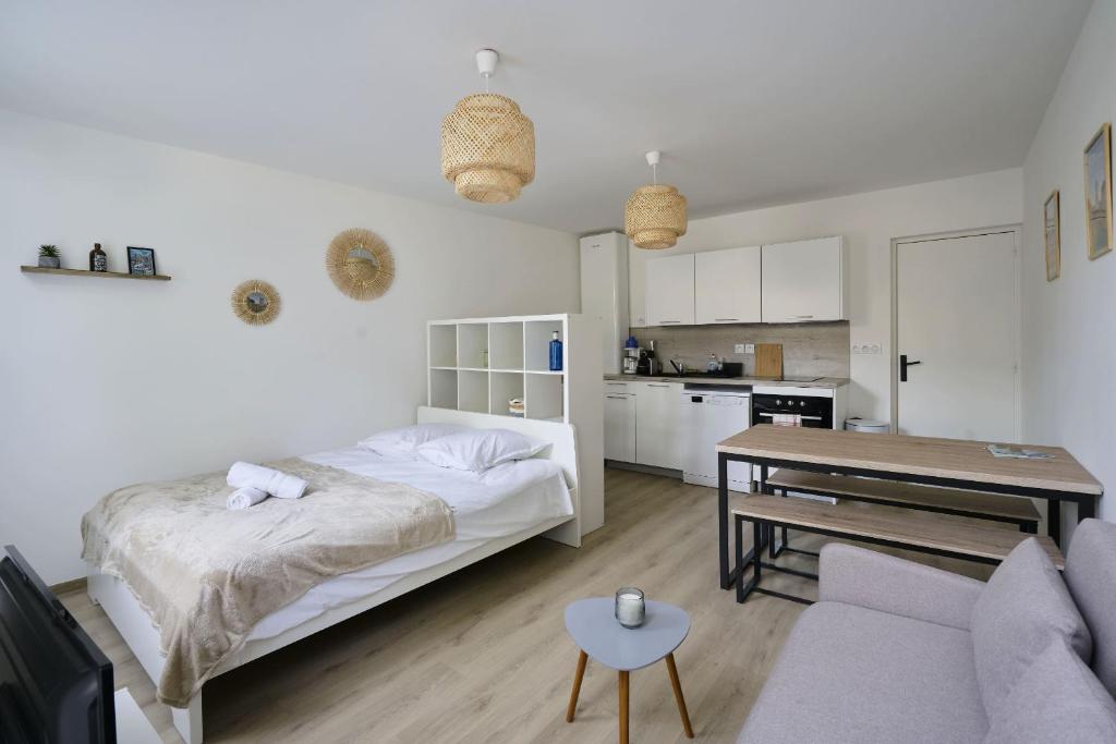 une chambre blanche avec un lit et une cuisine dans l'établissement Au Cœur des Remparts - Studio 2p, vieille ville BSM, à Boulogne-sur-Mer