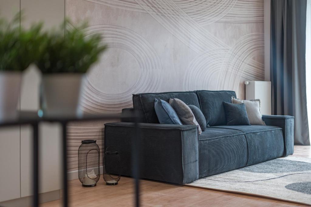 - un canapé bleu dans le salon dans l'établissement Apartamenty Falista Łódź Retkinia, à Łódź