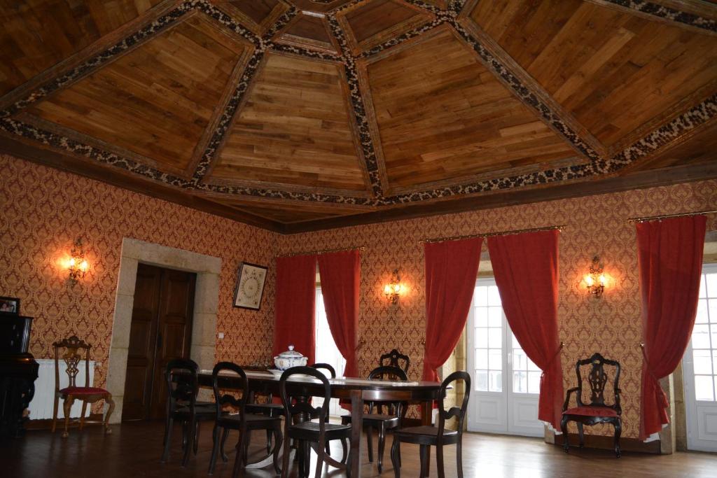 une salle à manger avec une table et des rideaux rouges dans l'établissement Solar dos Correia Alves, à Moimenta da Beira