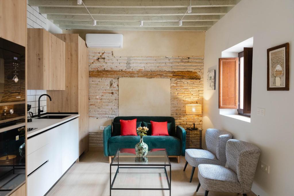 Hotel Apartamento Dúplex con vista a la Alhambra, a living room with a green couch and red pillows at Apartamento Dúplex con vista a la Alhambra in Granada