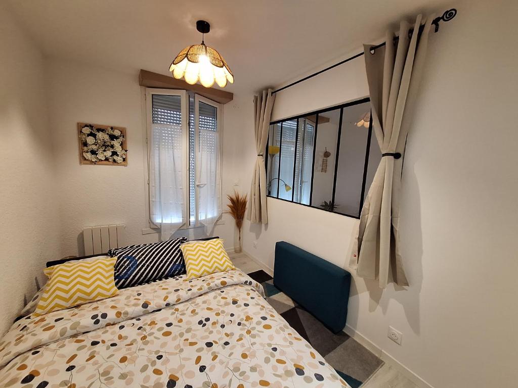 a bedroom with a bed and a window at Joli T2 rénové bord plan d'eau in Saint-Jean-dʼAngély