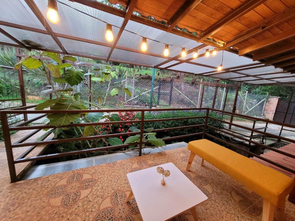 a room with a bench and a table at La Pascana Ecolodge frente al parque Arví Entorno natural excepcional, reserva natural, áreas protegidas, conexión con la naturaleza y avistamiento de aves a 3km del metrocable Guarne in Guarne