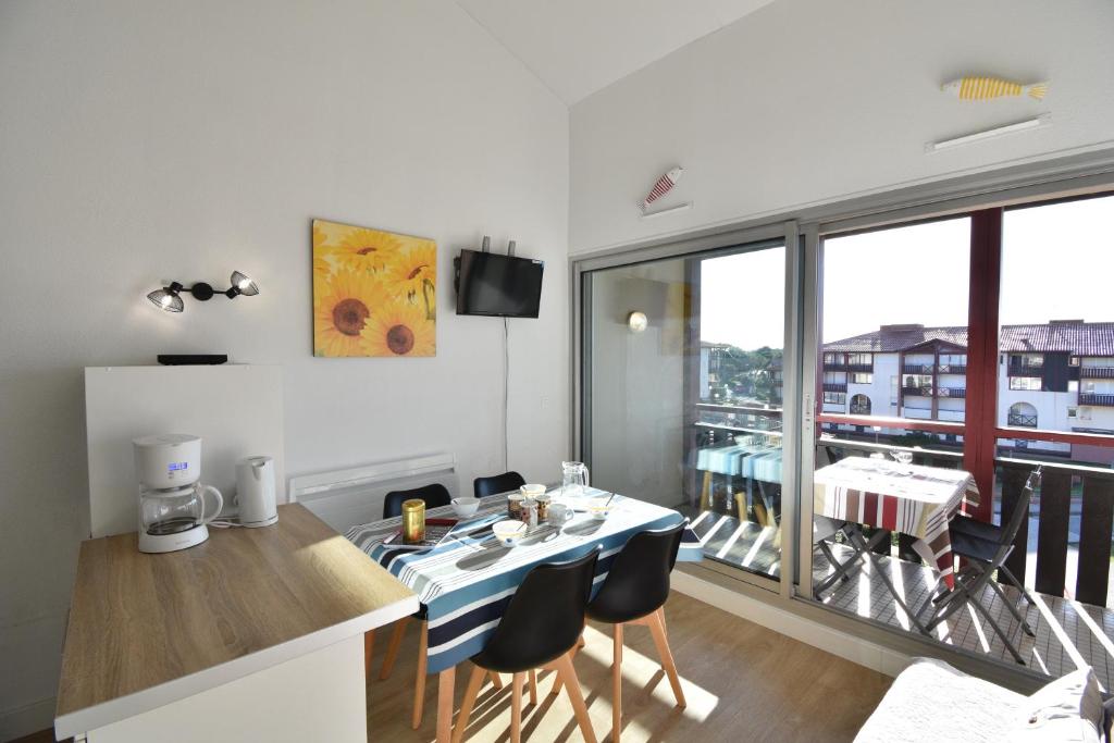 une cuisine et une salle à manger avec une table et des chaises dans l'établissement Point d'or B - Hossegor agréable studio en duplex situé dans une résidence avec piscine en bord de plage, à Soorts-Hossegor