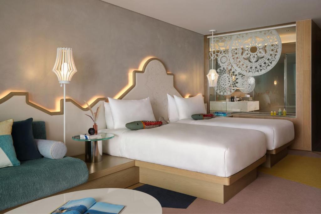 a bedroom with a large white bed and a couch at W Algarve in Albufeira