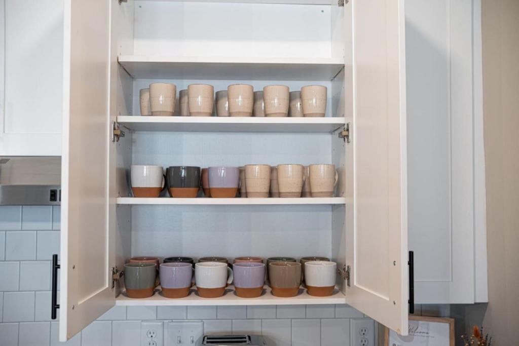 einen Küchenschrank mit Töpfen und Pfannen in der Unterkunft Charming, New Apt, Pool, Long Stays in Athens