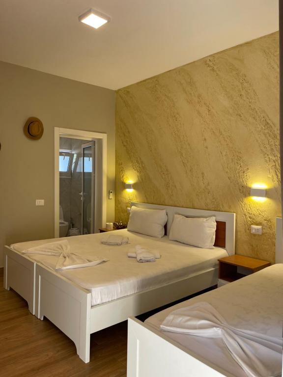 a bedroom with two beds and a bathroom at Vila Arial in Vlorë