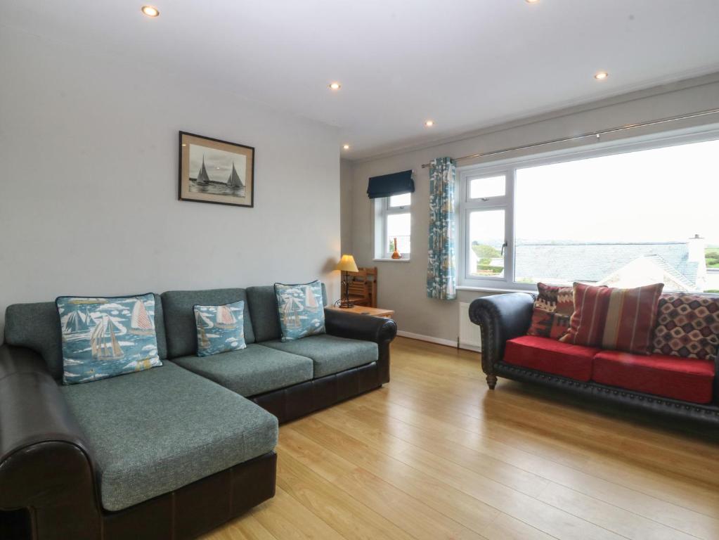 a living room with a couch and a window at Ty Nant in Abersoch