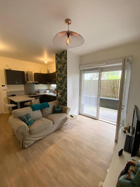 un salon avec un canapé et une table et une cuisine dans l'établissement Appartement 2 pièces proche Paris et Orly, à Choisy-le-Roi