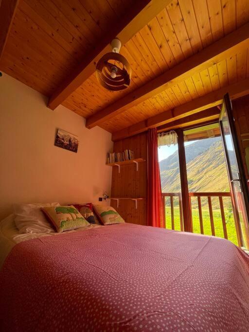 une chambre avec un lit et une grande fenêtre dans l'établissement T2 5 p Champagny-le-Haut, à Champagny-en-Vanoise