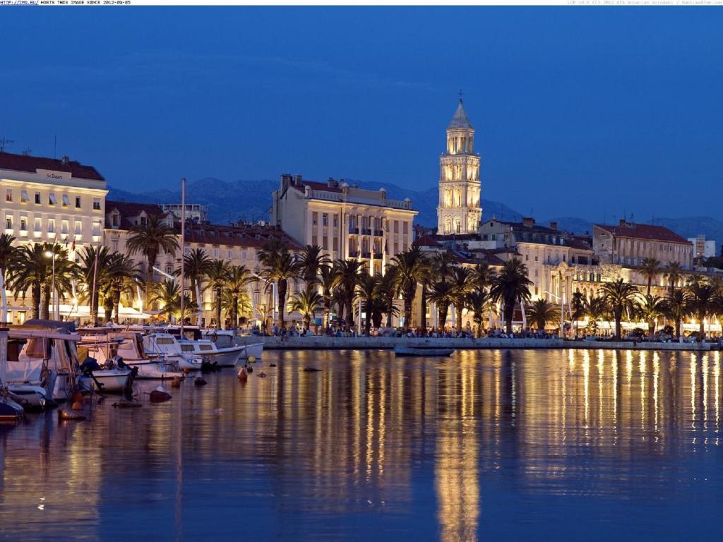 een stad met een klokkentoren en boten in het water bij Apartment Onyx in Split