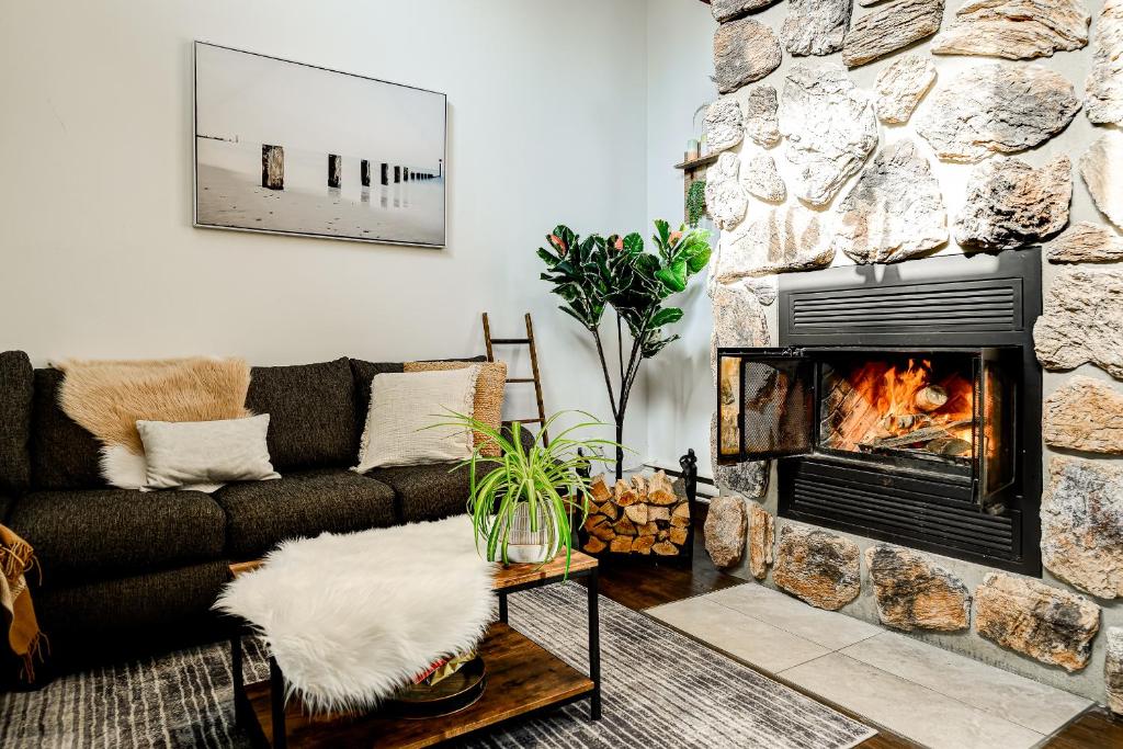 a living room with a couch and a fireplace at Le Alesund, 5BR avec SPA, PLAGE et embarcations in Sainte-Lucie-de-Doncaster