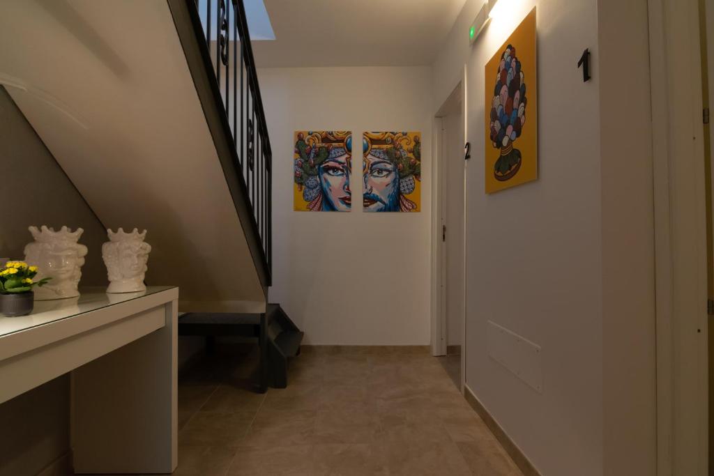 einen Flur mit zwei Gemälden an der Wand in der Unterkunft R-Home Exclusive Rooms in Catania