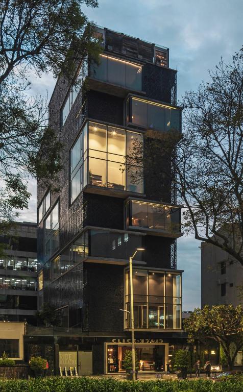 ein hohes Gebäude mit vielen Glasfenstern in der Unterkunft The Click Clack Hotel Bogotá in Bogotá