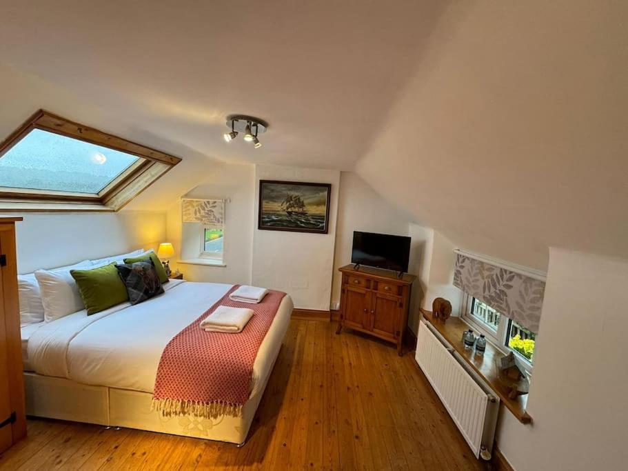 a bedroom with a large bed and a television at The Snug at Cherry Cottage by MaisonPro in Matson
