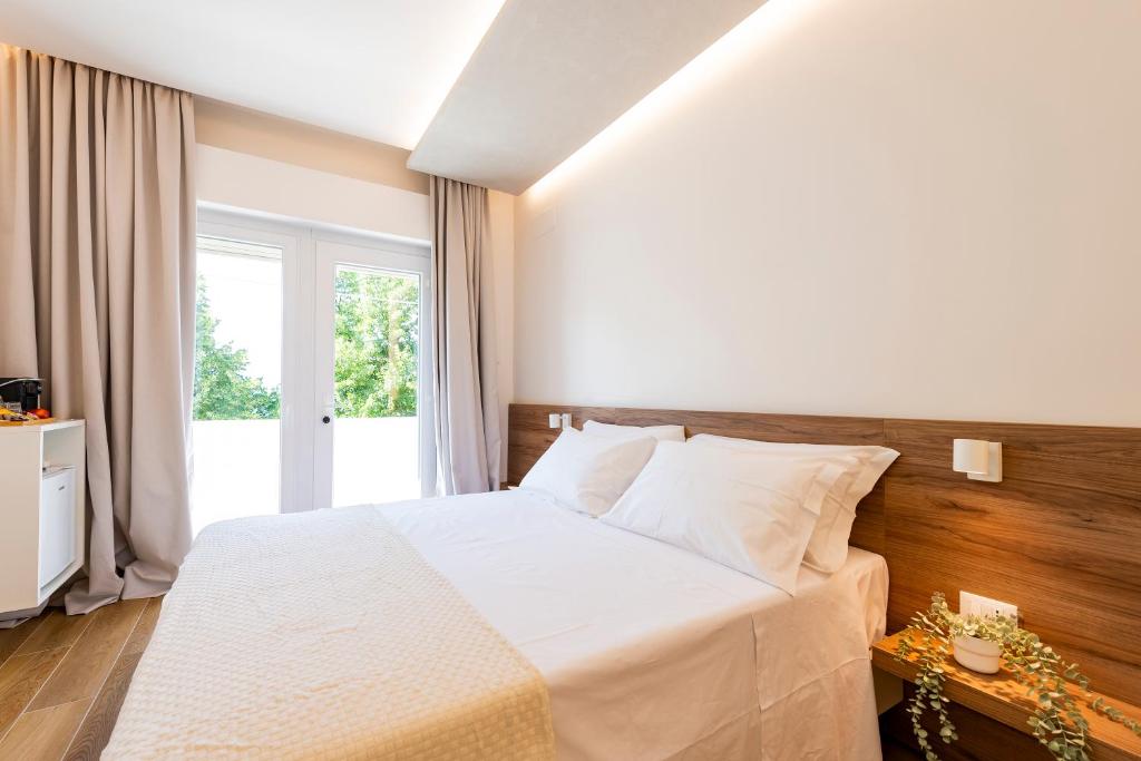a bedroom with a white bed and a window at Affittacamere La Nuvola in Chieti