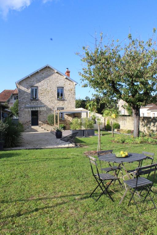 a picnic table in the yard of a stone house at " La belle vie ", Demeure de charme en Champagne in Dormans