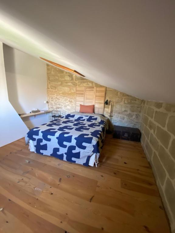 a bedroom with a blue and white bed in a attic at La malle bleue in Vallabrix