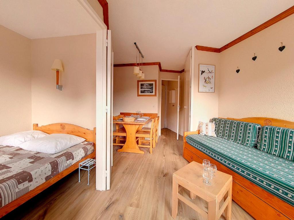 une chambre avec deux lits et une table dans l'établissement Appartement cosy 2 pièces - Proche pistes et commerces - Balcon Sud/Est - Parking gratuit - FR-1-344-973, aux Menuires