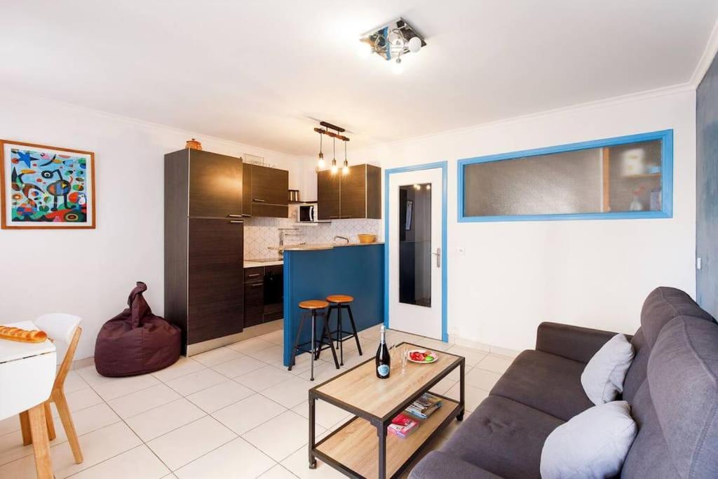 un salon avec un canapé et une cuisine dans l'établissement Charmant studio près de la mer, à Cannes