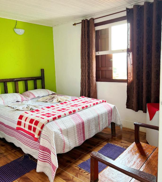 a bedroom with a bed and a green wall at Suítes Cantinho Gostoso in Lavras Novas