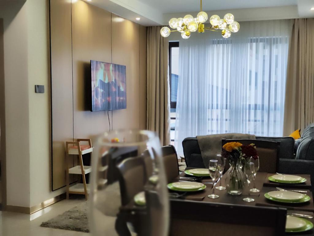 a living room with a table and a couch at Lola's Haven - 75" Screen, Heated Pool, Gym, Views in Nairobi