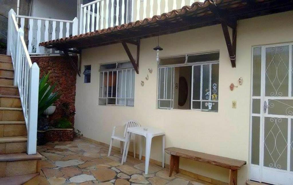 a white house with a table and a stairs at Pousada Presidente in Diamantina